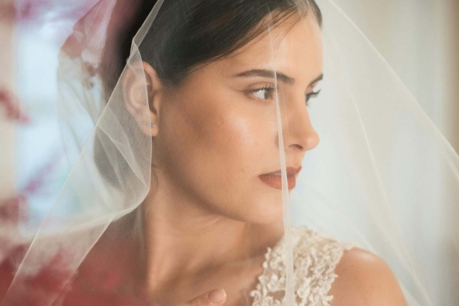 A serene bridal portrait capturing an elegant bride behind a veil.